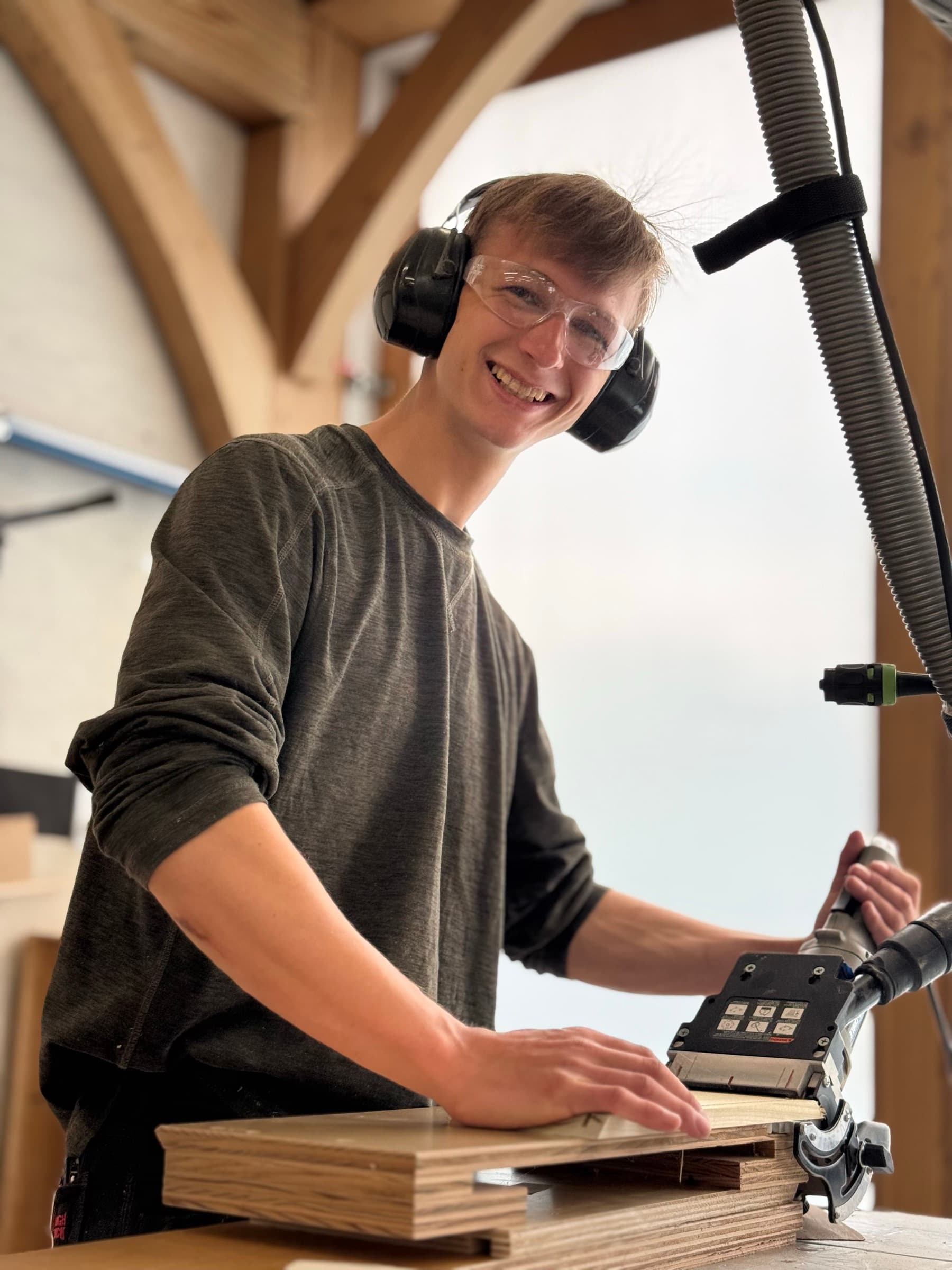 Aidan Gilbert smiling in the shop while working with hearing and eye protection